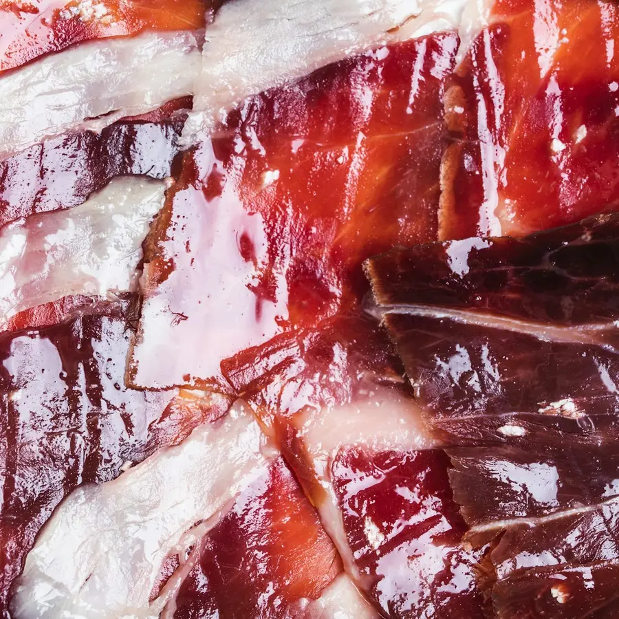 Lonchas finas de jamón ibérico de bellota cortadas a cuchillo, veteadas de grasa